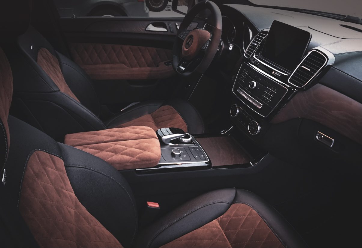 Mercedes-Benz GL salong: konjakipruun rombtepitud Alcantara mustal nahal, kaetud keskkonsool ja armatuur.