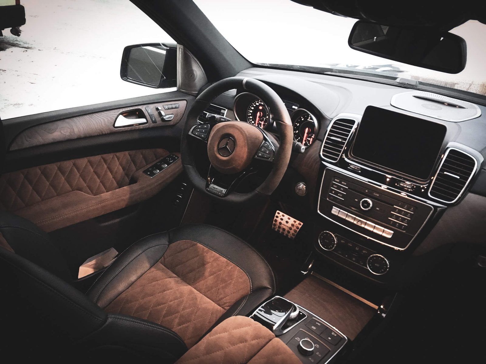 Mercedes-Benz GL salong: pruun Alcantara rombtepp mustal nahal, armatuurlaud ja keskkonsool.